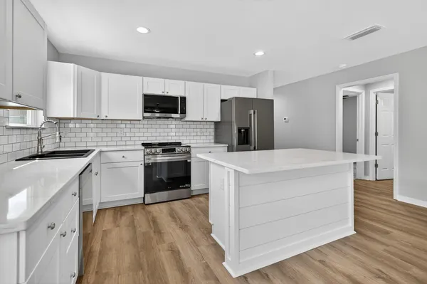 a kitchen with a refrigerator a sink and cabinets