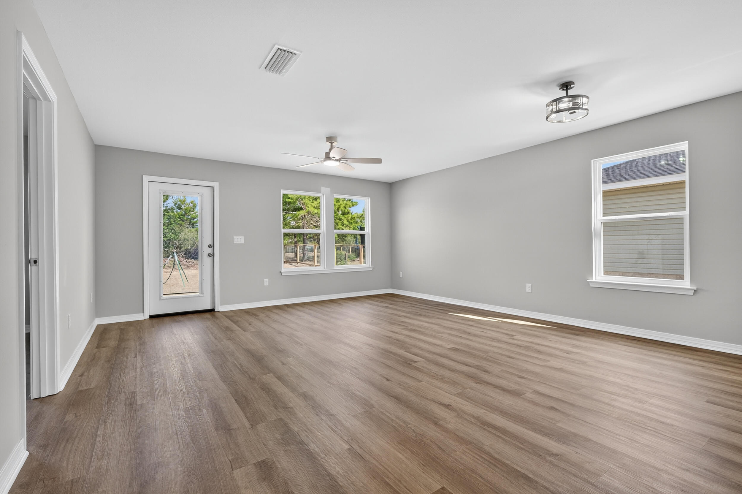 5327 B Kervin Road Crestview, FL 32539 - Photo 18 of 47 an empty room with wooden floor and windows