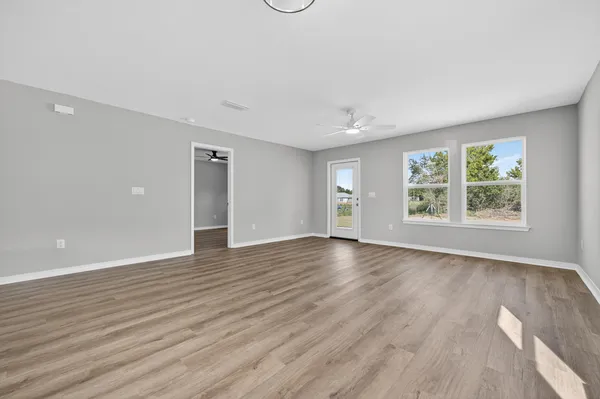 a view of empty room with wooden floor