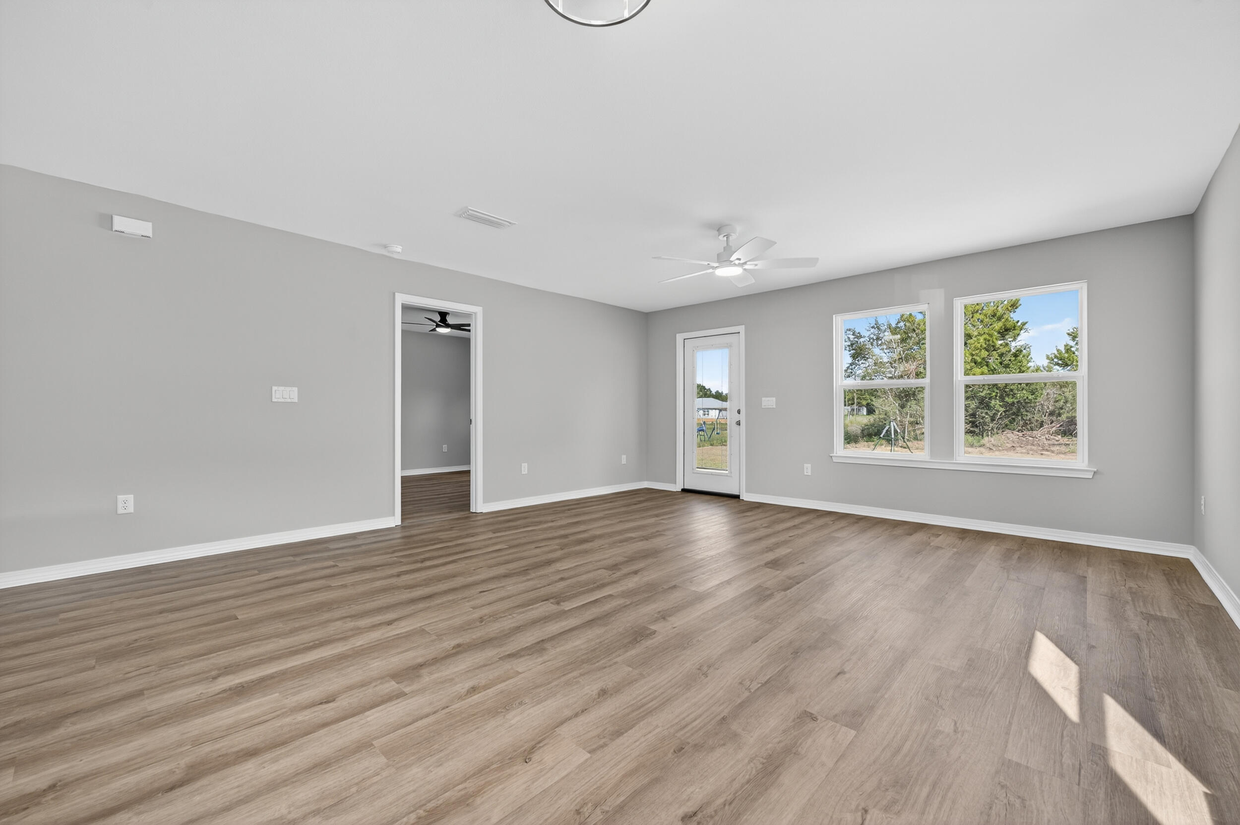 5327 B Kervin Road Crestview, FL 32539 - Photo 19 of 47 an empty room with wooden floor and windows