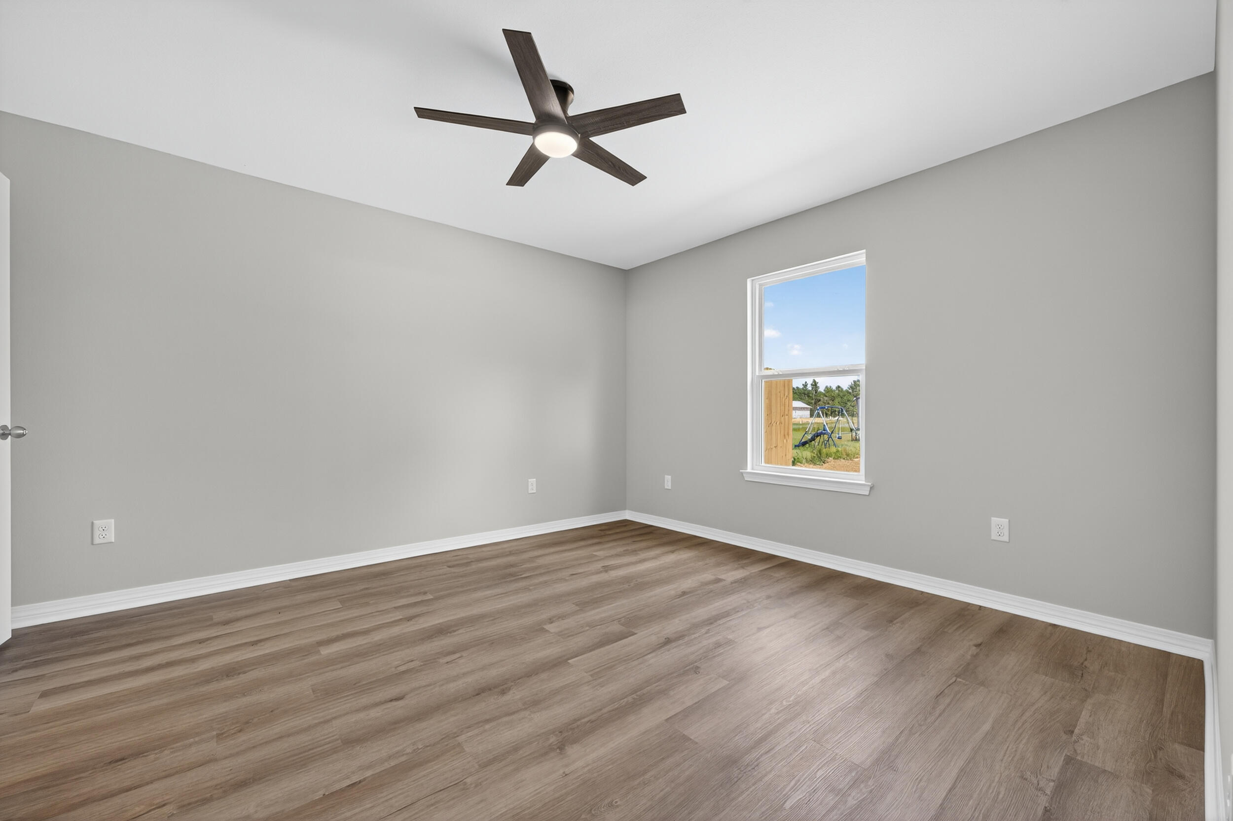 5327 B Kervin Road Crestview, FL 32539 - Photo 22 of 47 an empty room with wooden floor and windows