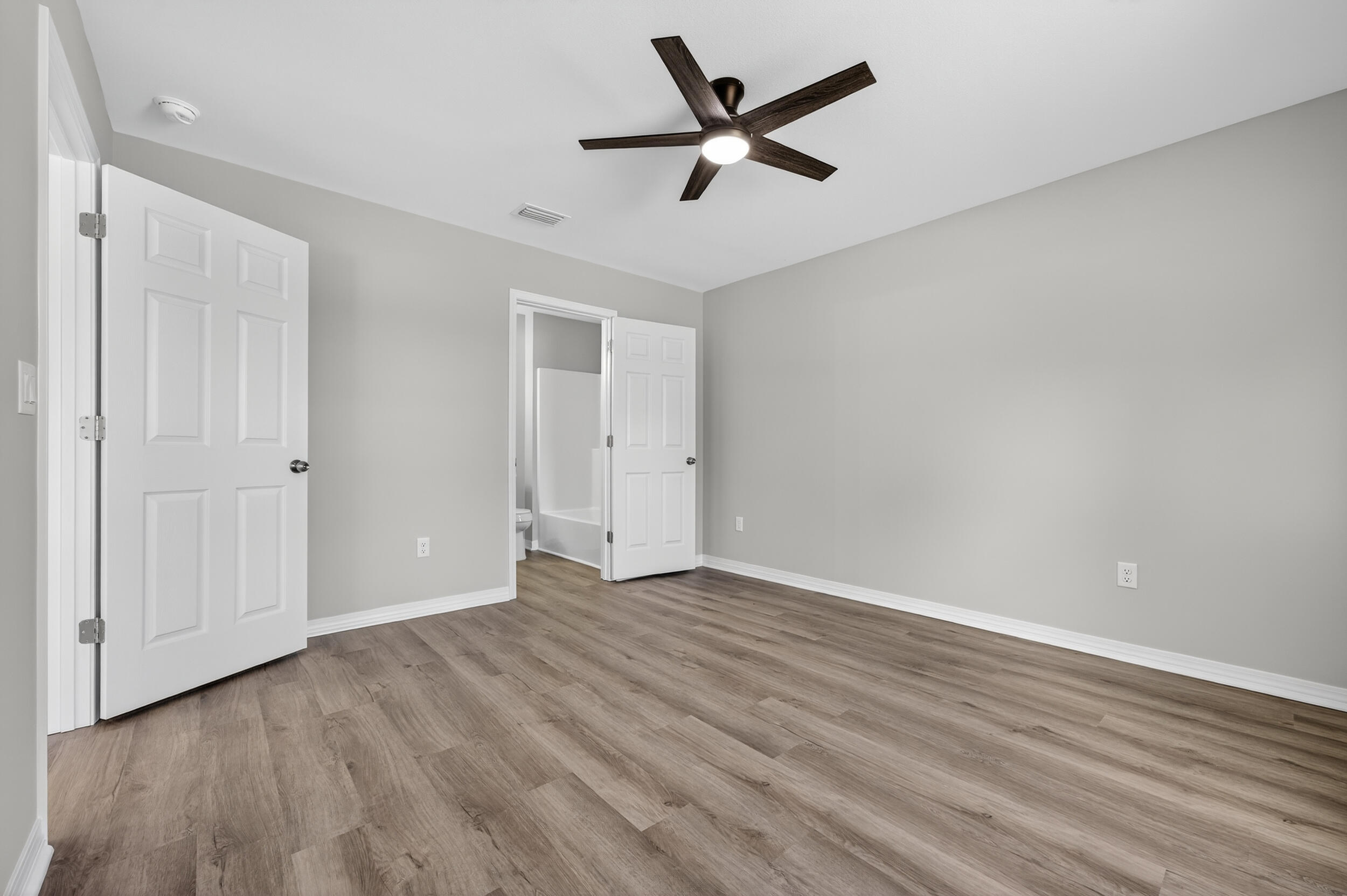 5327 B Kervin Road Crestview, FL 32539 - Photo 25 of 47 an empty room with wooden floor and windows