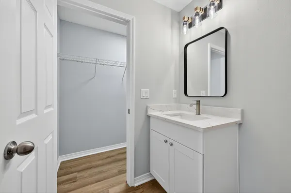 a bathroom with a bathtub shower sink vanity mirror and toilet