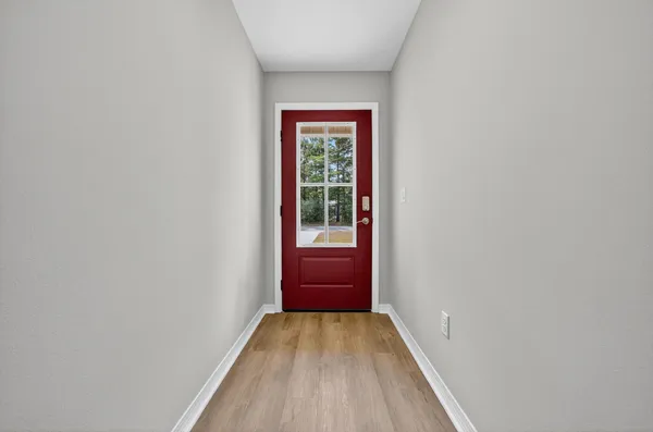 a view of hallway with a large window and wooden floor