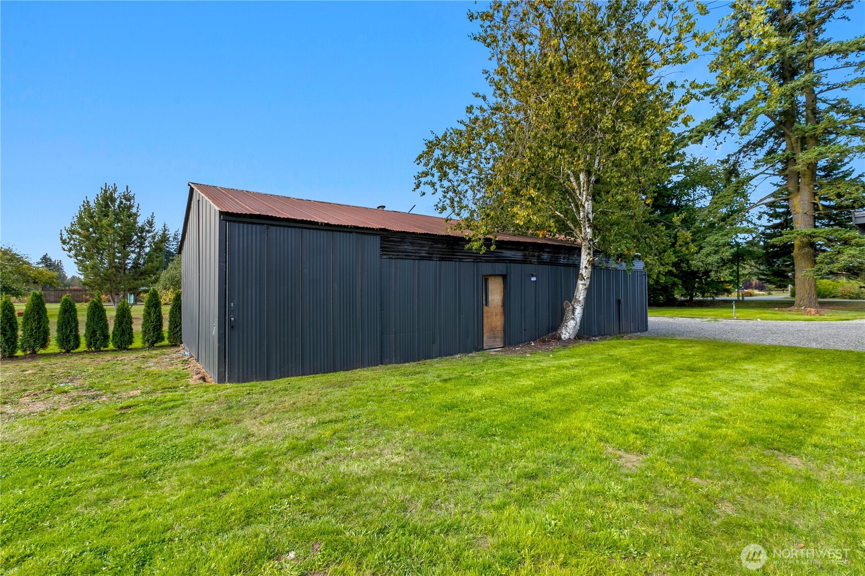 893 Loomis Trail Road Lynden, WA 98264 - Photo 27 of 39 a view of a backyard with large trees and wooden fence