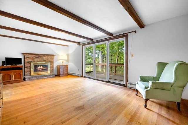 a view of a livingroom with furniture a fireplace and wooden floor