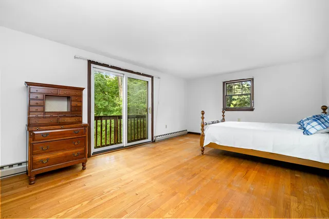a bedroom with bed and wooden floor