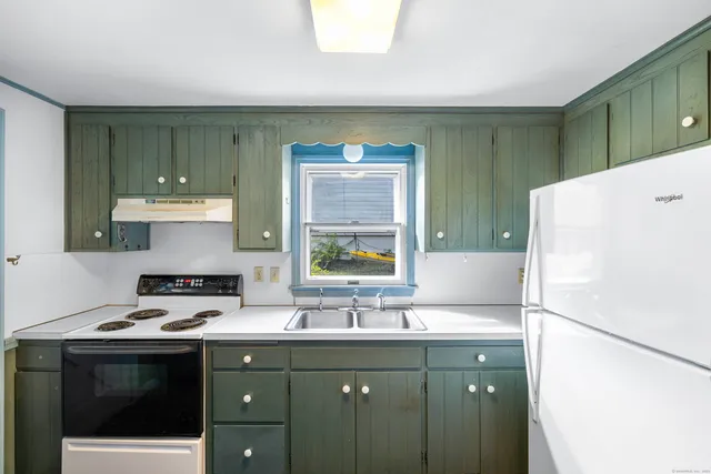 a kitchen with a sink cabinets and a refrigerator