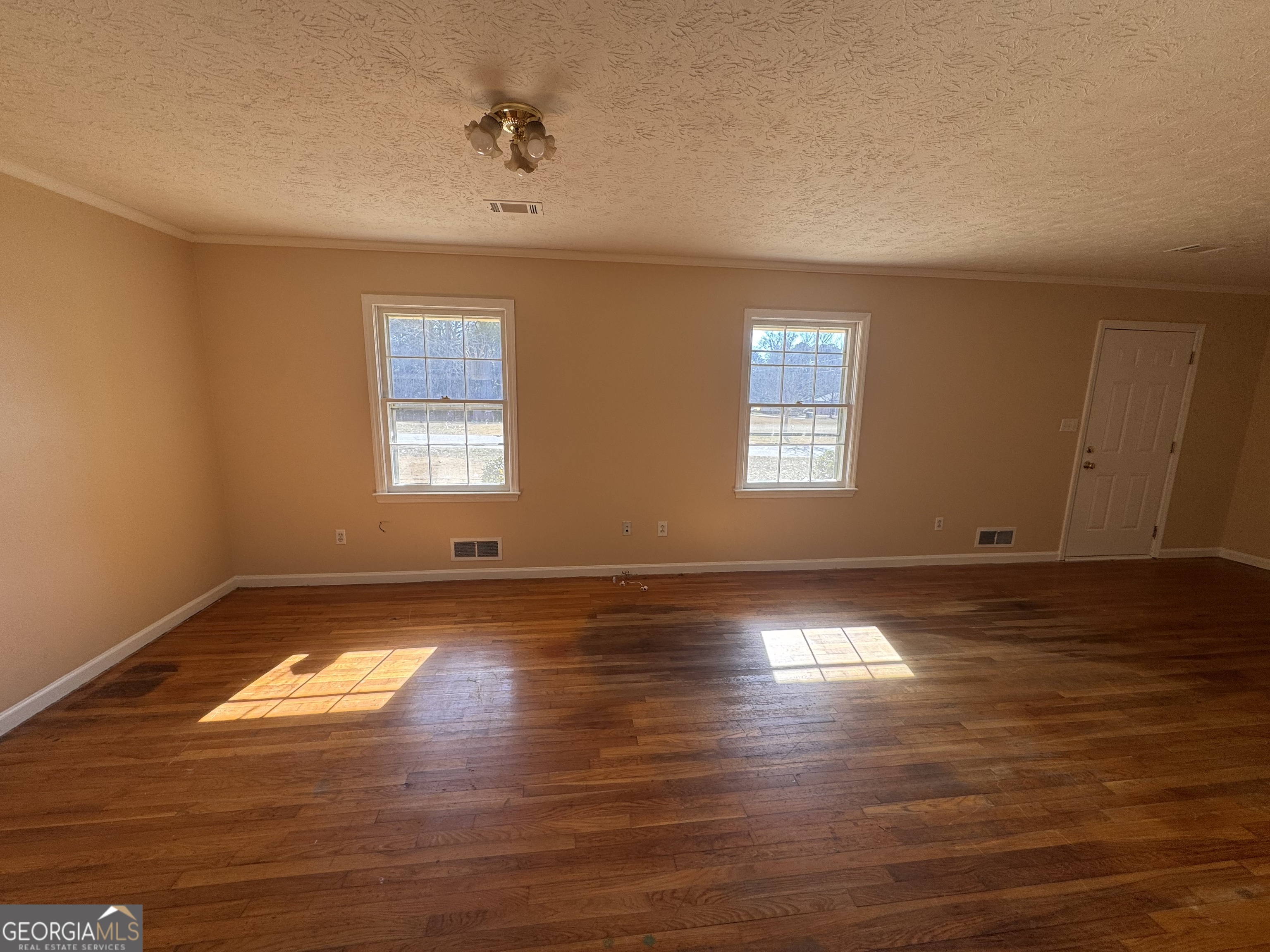 5175 Forest Drive Southeast Covington, GA 30014 - Photo 4 of 30 a view of an empty room with window and wooden floor