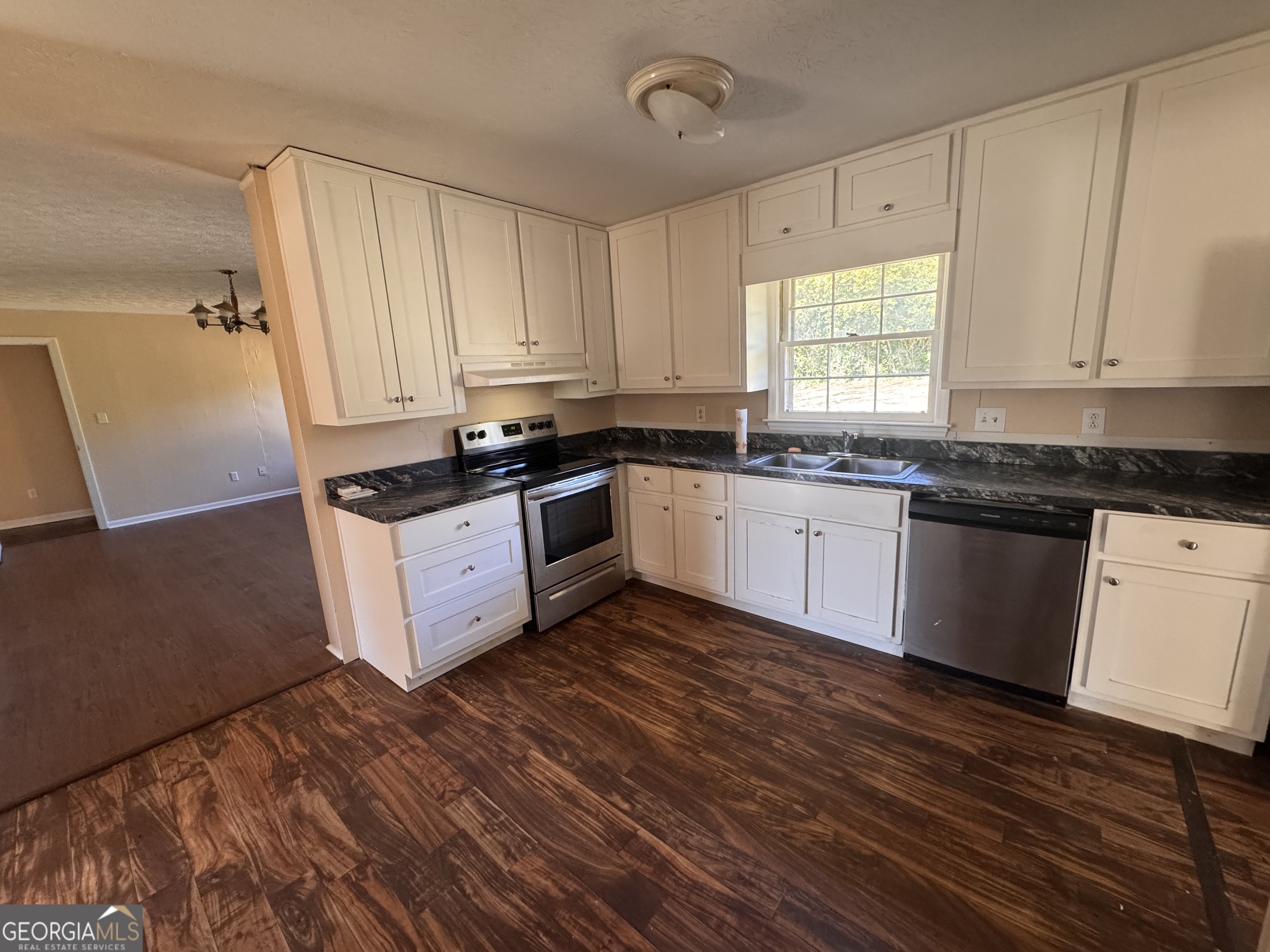 5175 Forest Drive Southeast Covington, GA 30014 - Photo 5 of 30 a kitchen with granite countertop a sink a stove and cabinets