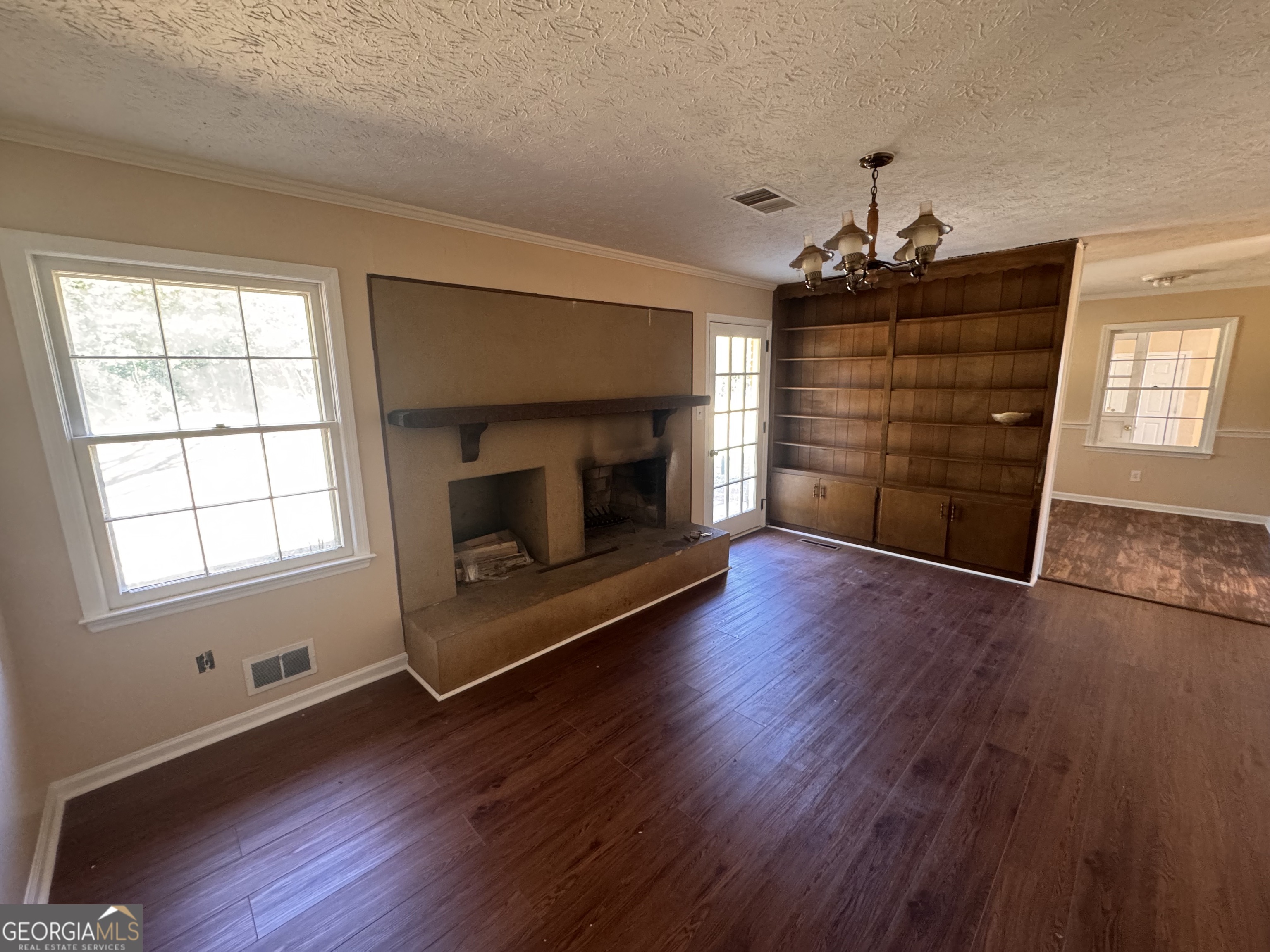 5175 Forest Drive Southeast Covington, GA 30014 - Photo 10 of 30 an empty room with wooden floor fireplace cabinet and windows