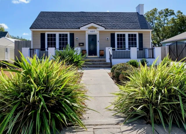 a front view of a house with yard and plants