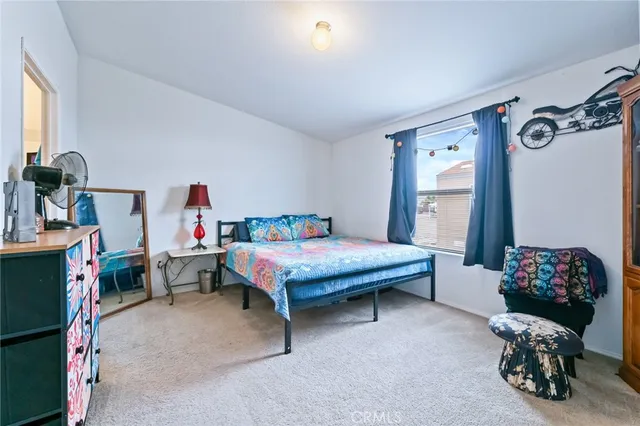a bedroom with a bed and a flat tv screen on wall
