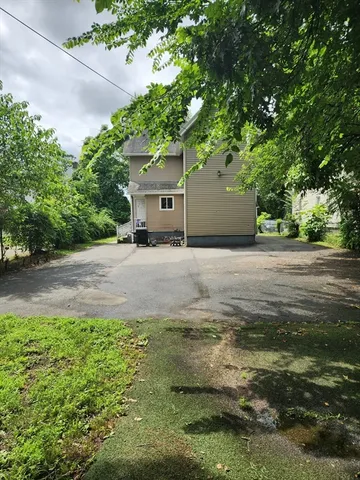 a front view of a house with a garden and yard