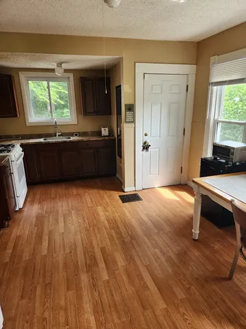 a living room with a couch wooden floor and a window