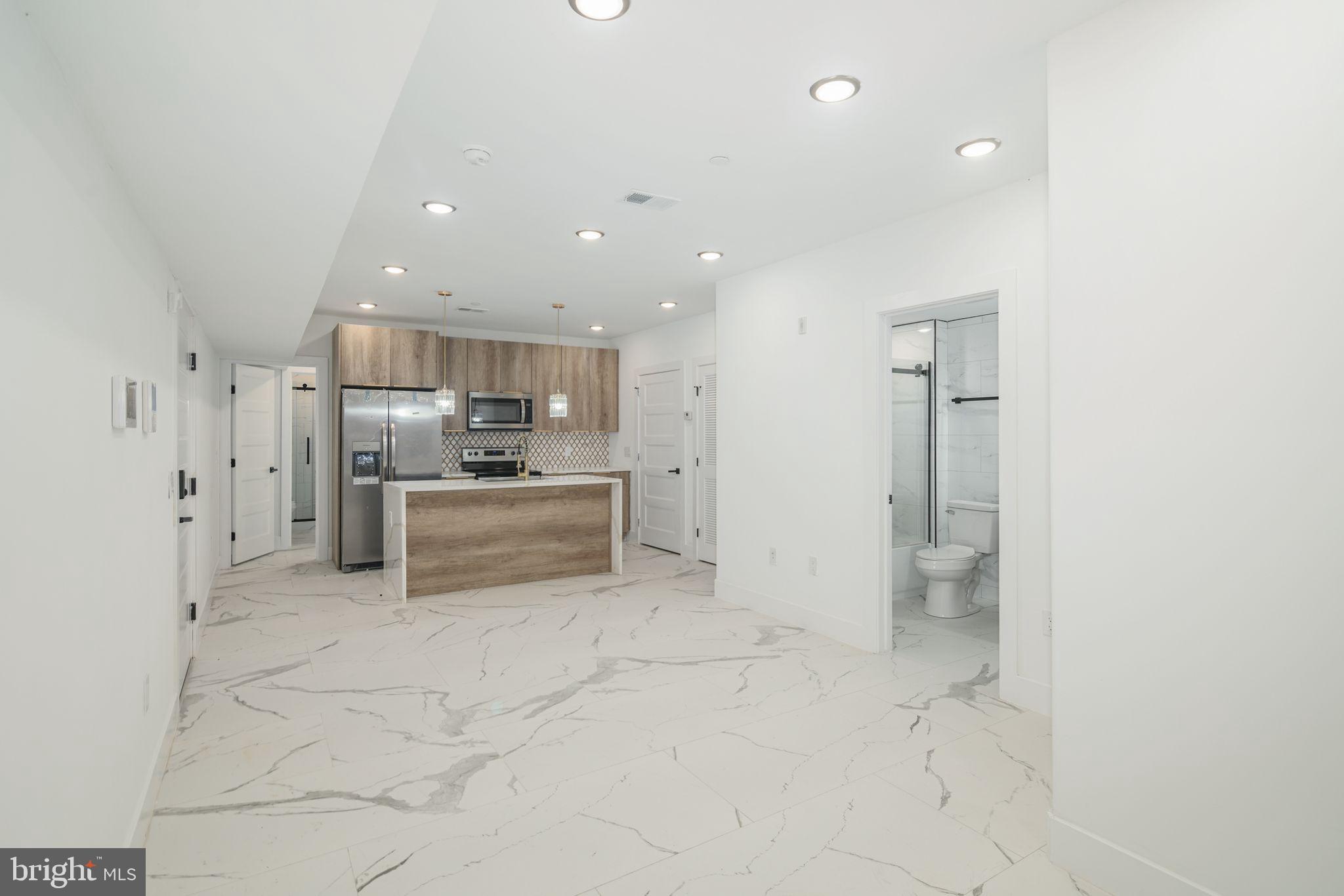 a large white kitchen with a refrigerator a stove a sink and a cabinets