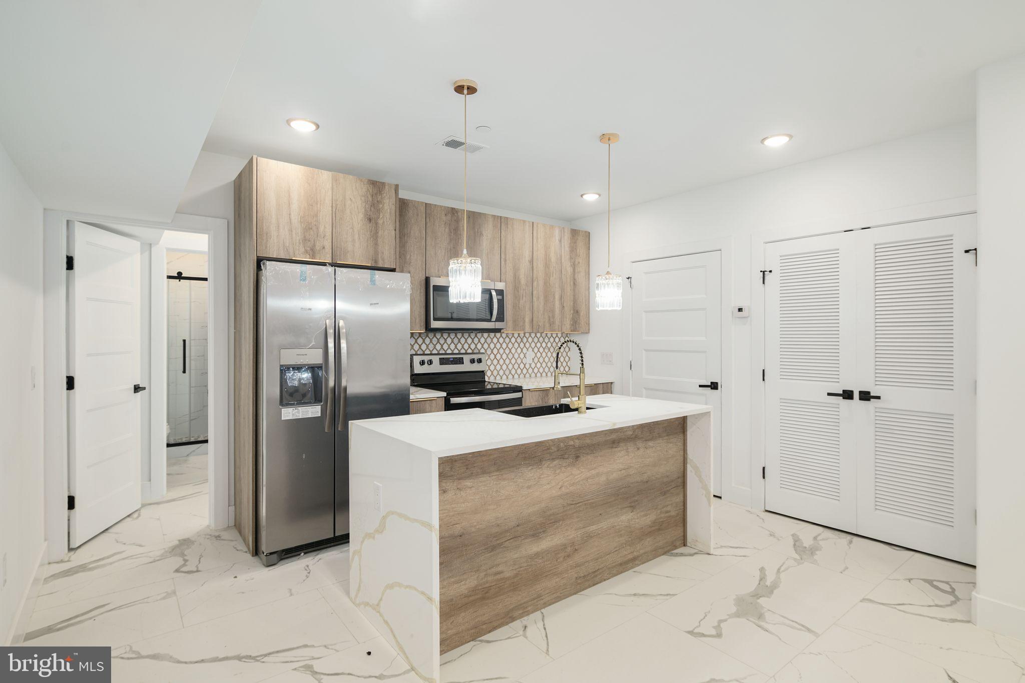 2000 North Front Street, Unit 21 Philadelphia, PA 19122 - Photo 2 of 20 a kitchen with granite countertop a refrigerator sink and cabinets
