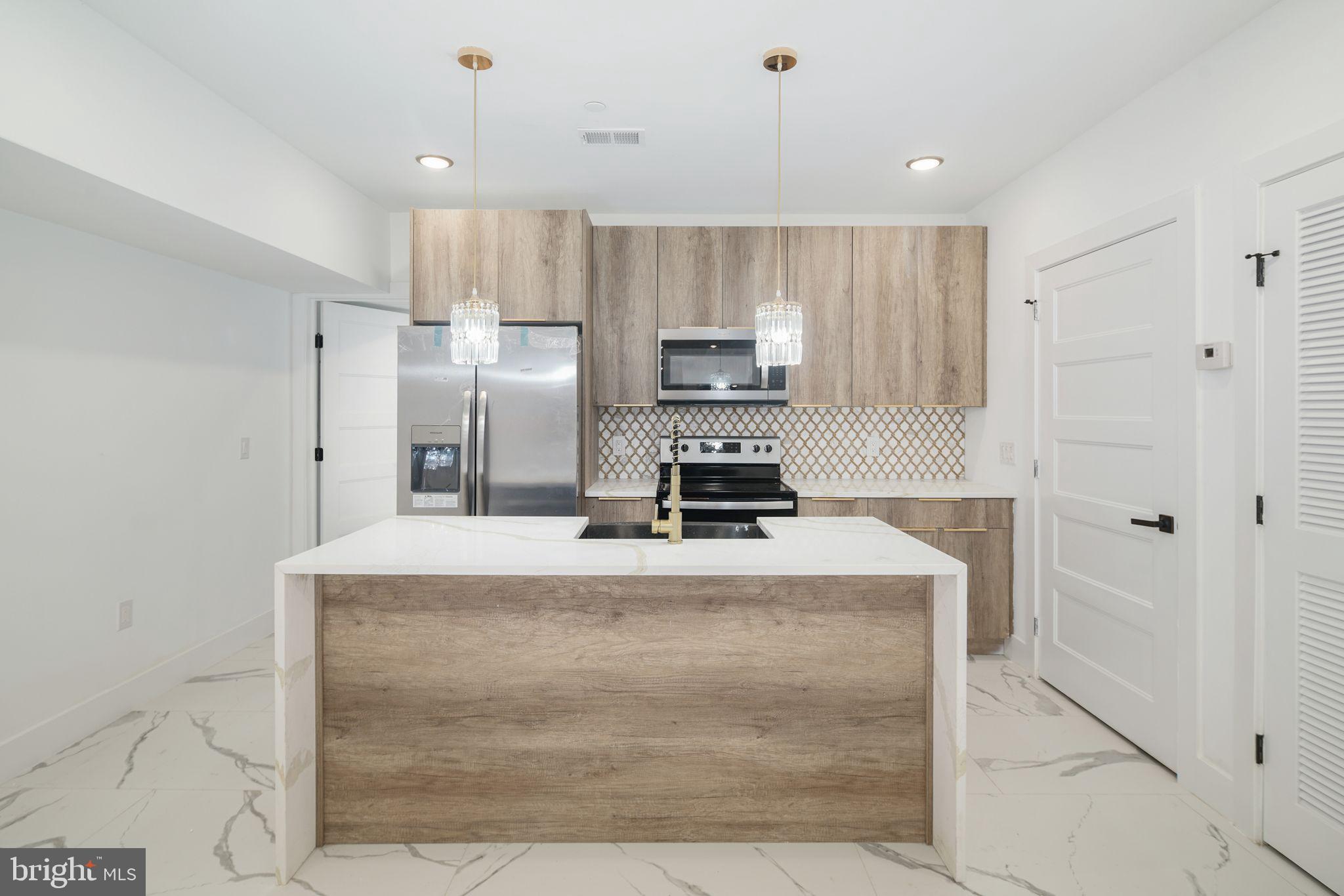 2000 North Front Street, Unit 21 Philadelphia, PA 19122 - Photo 3 of 20 a large kitchen with cabinets and a refrigerator