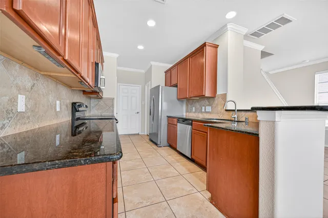 a kitchen with stainless steel appliances granite countertop a sink and a stove
