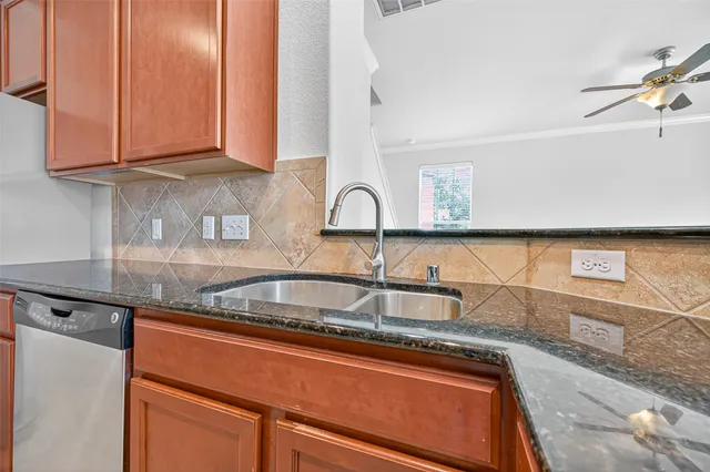 a kitchen with granite countertop a sink and cabinets