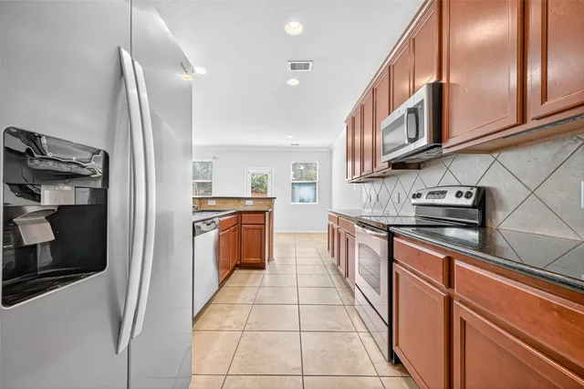 a kitchen with stainless steel appliances granite countertop a stove and a refrigerator