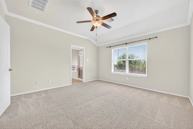 an empty room with ceiling fan and window