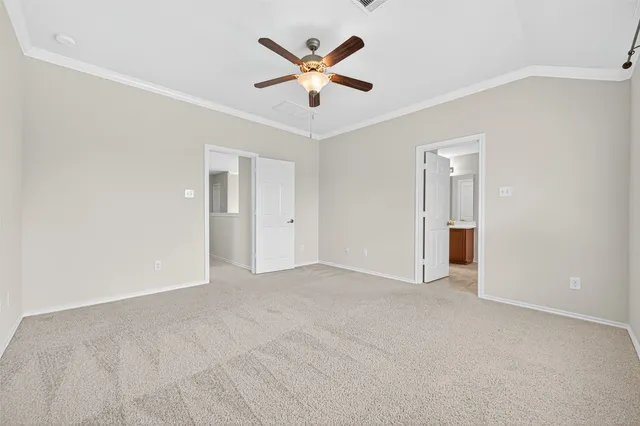 an empty room with closet and ceiling fan