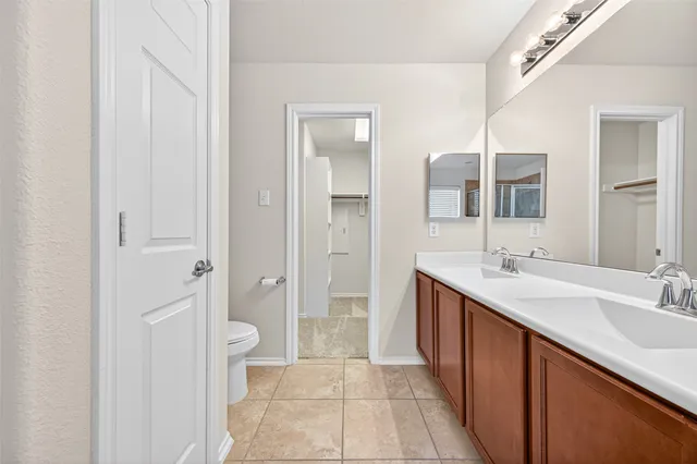 a spacious bathroom with a double vanity sink a mirror and a shower