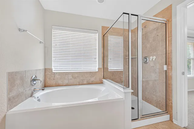 a white bath tub sitting next to a shower