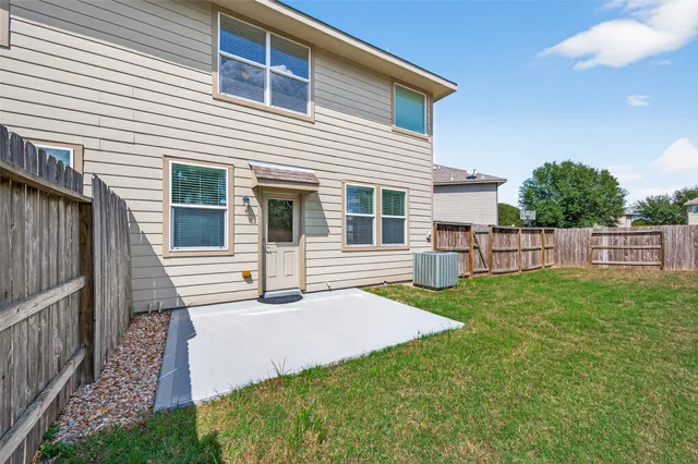 a view of a house with backyard and wooden fence