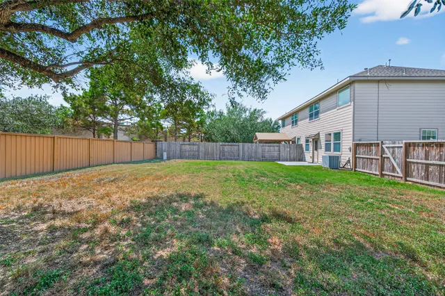 a view of a backyard with table and chairs and wooden fence