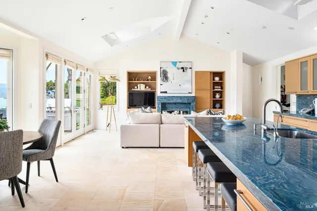 a view of a kitchen with kitchen island granite countertop a sink and a large window