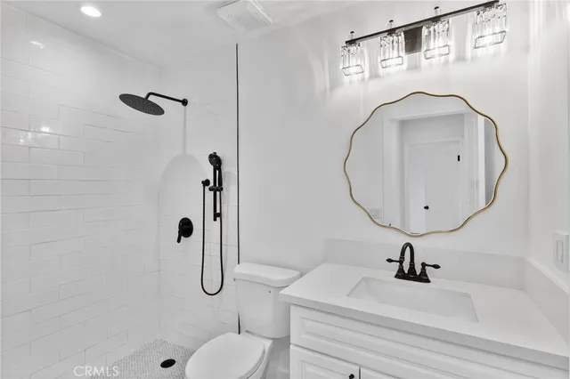 a bathroom with a sink a toilet and a mirror