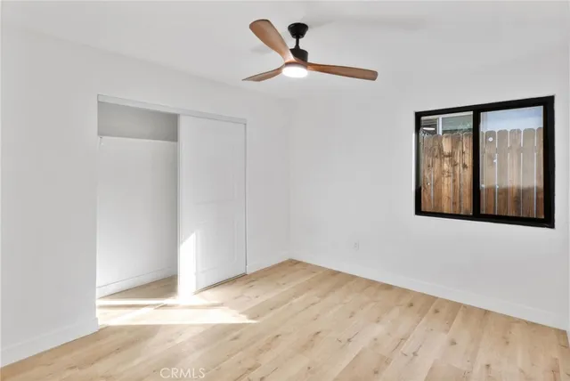 a view of a livingroom with wooden floor and a ceiling fan
