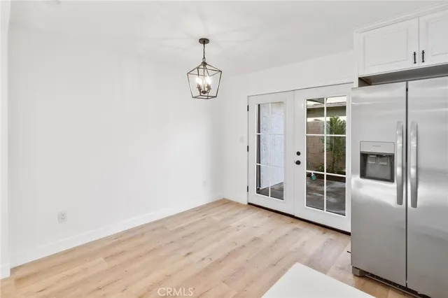 an empty room with wooden floor and appliances