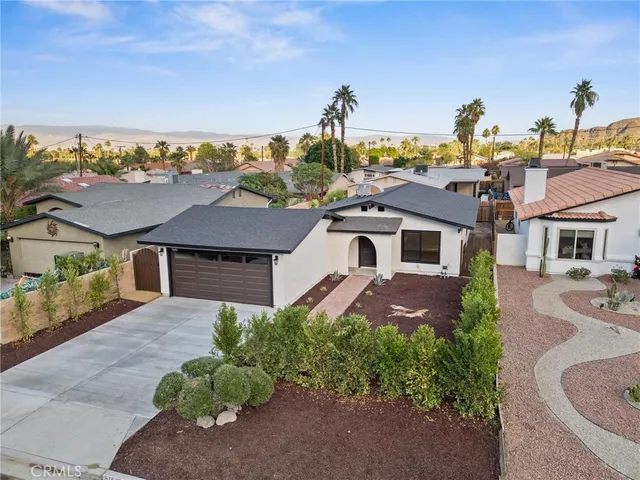 a front view of a house with a yard garage and outdoor seating