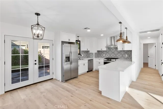 a view of a kitchen with wooden floor and electronic appliances