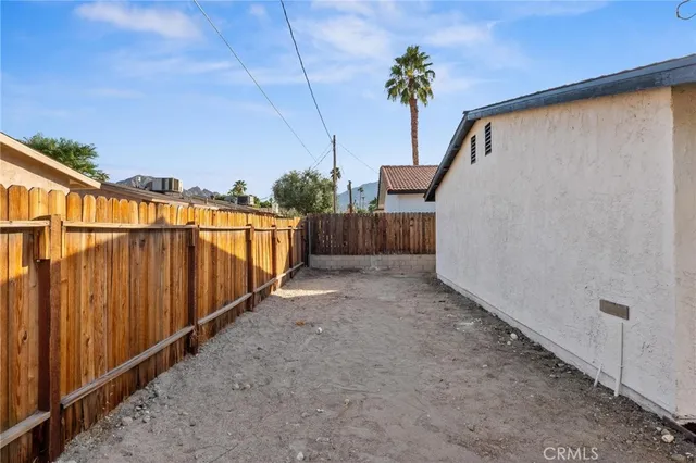 a view of a pathway of a yard with wooden fence