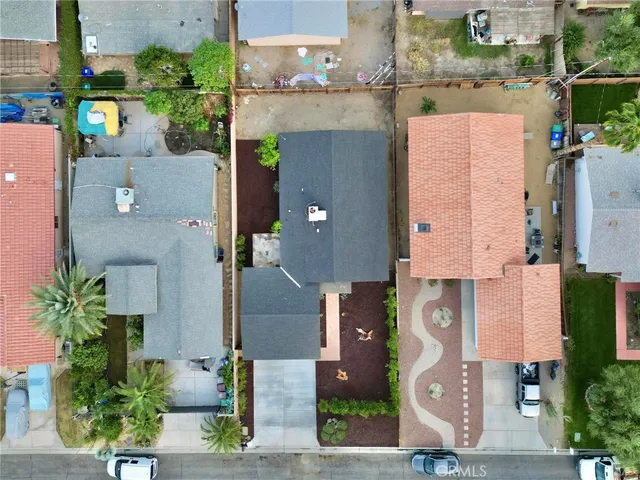 an aerial view of residential houses with outdoor space and parking