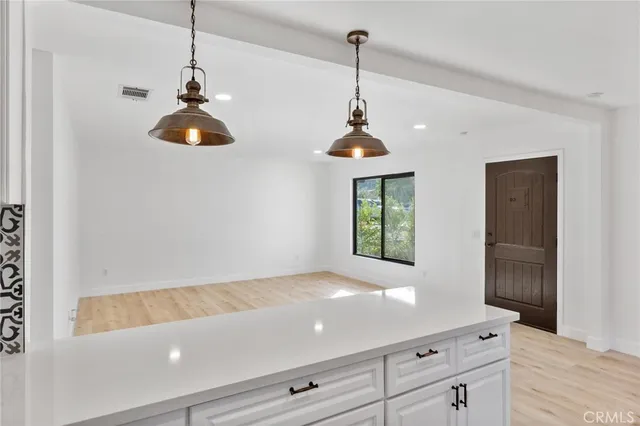 a view of an entryway with wooden floor and cabinets