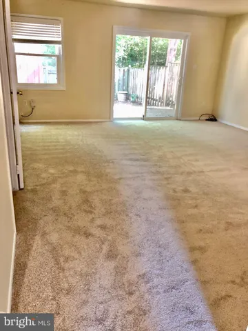 en empty room with windows and a ceiling fan