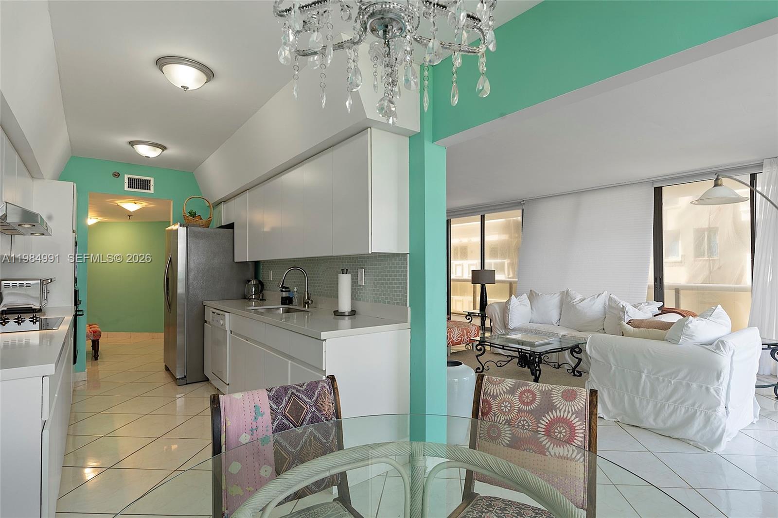 9455 Collins Avenue, Unit 409 Surfside, FL 33154 - Photo 12 of 46 a living room with furniture and a chandelier