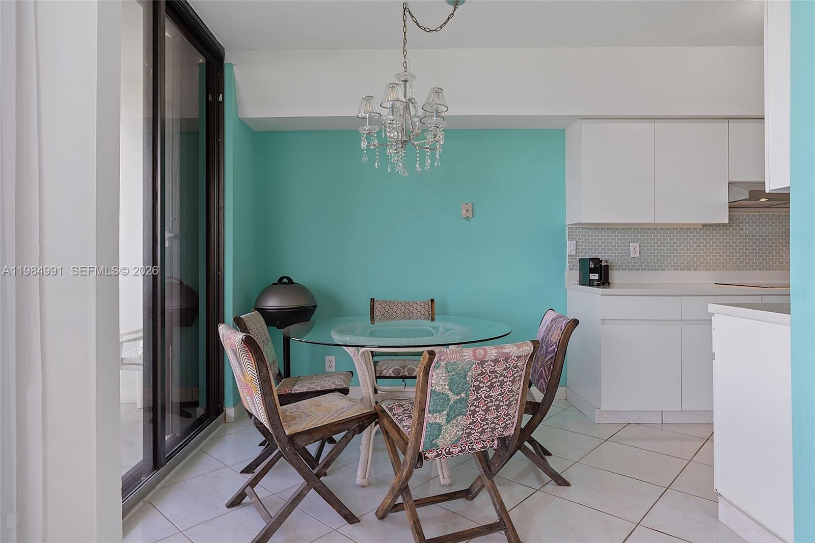 9455 Collins Avenue, Unit 409 Surfside, FL 33154 - Photo 16 of 46 a view of a dining room with furniture and chandelier