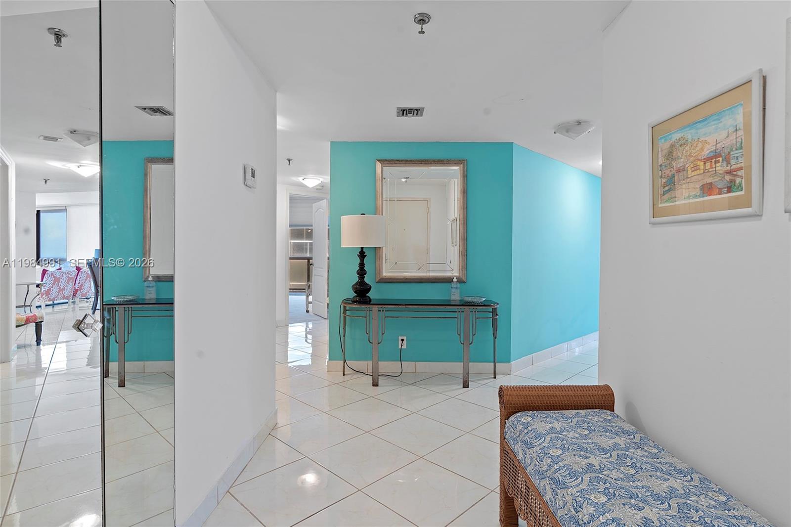 9455 Collins Avenue, Unit 409 Surfside, FL 33154 - Photo 17 of 46 a hallway with a dresser and mirror