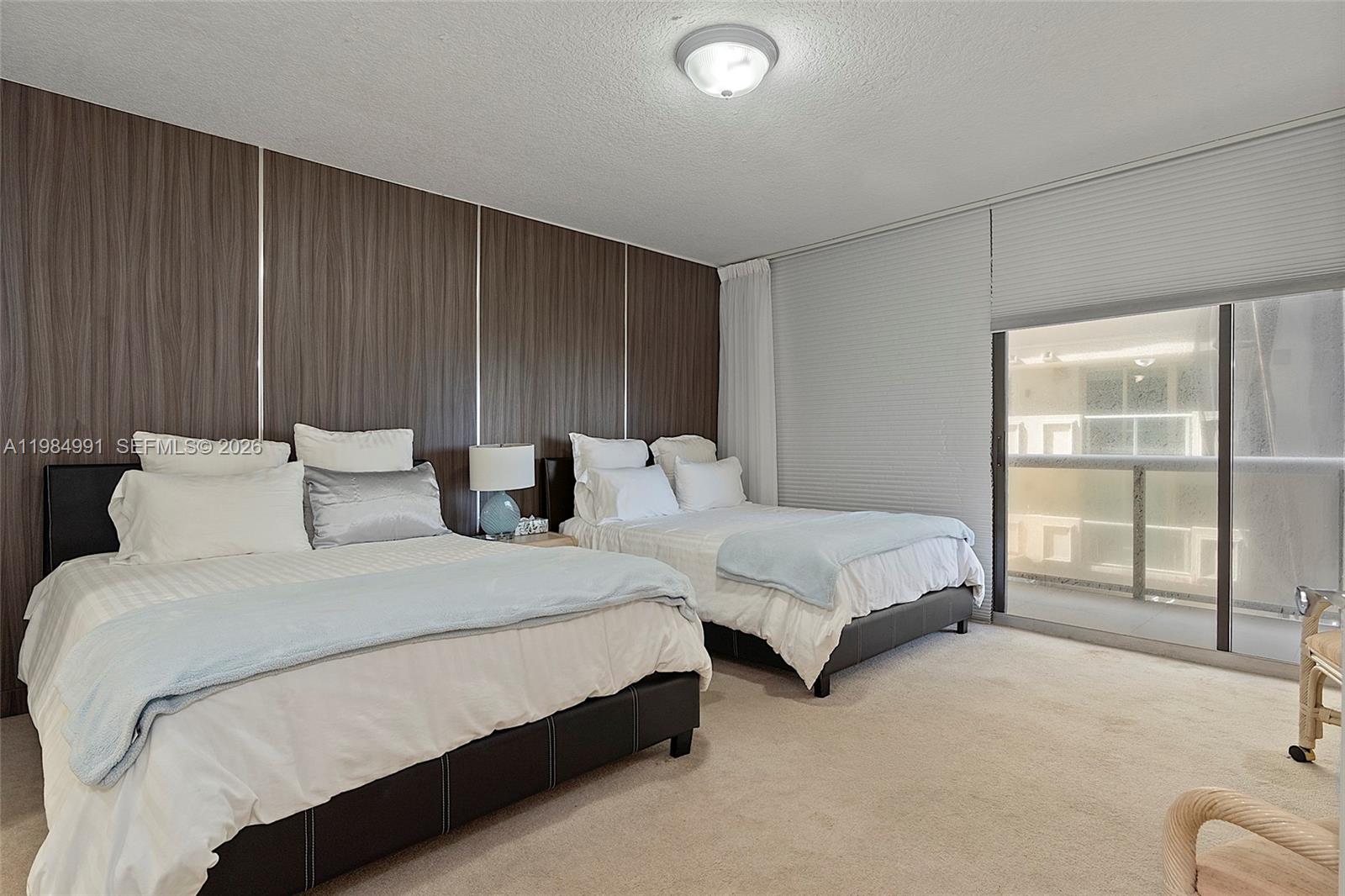 9455 Collins Avenue, Unit 409 Surfside, FL 33154 - Photo 19 of 46 a spacious bedroom with two beds and next to a window
