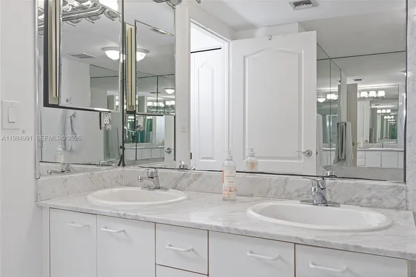 a bathroom with a granite countertop sink mirror and a shower
