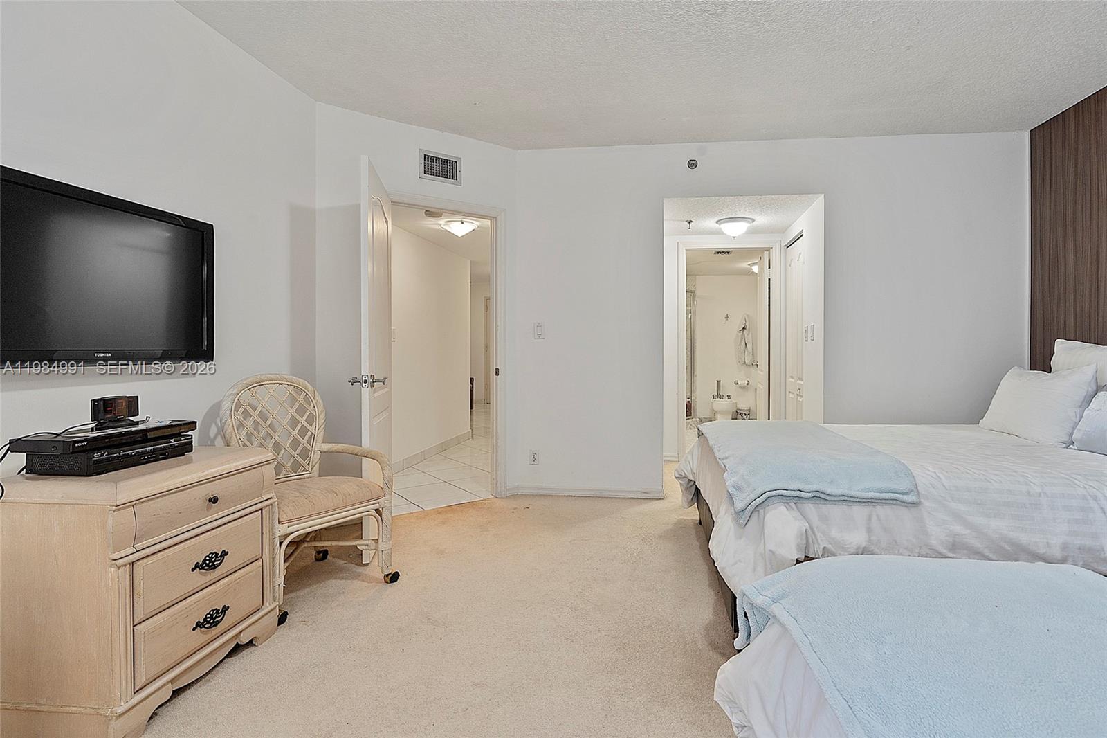 9455 Collins Avenue, Unit 409 Surfside, FL 33154 - Photo 43 of 46 a bedroom with furniture and a flat screen tv