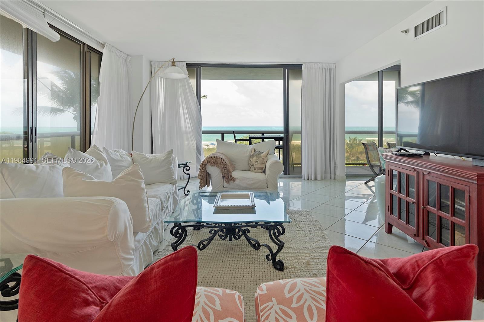 9455 Collins Avenue, Unit 409 Surfside, FL 33154 - Photo 6 of 46 a living room with furniture and a flat screen tv