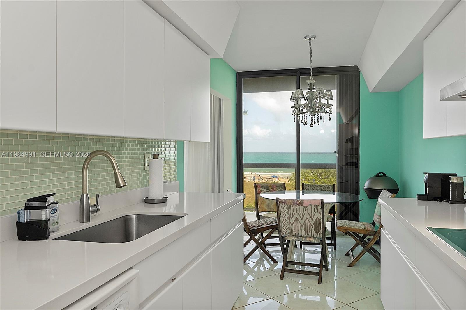 9455 Collins Avenue, Unit 409 Surfside, FL 33154 - Photo 10 of 46 a kitchen with a table chairs and outdoor shower