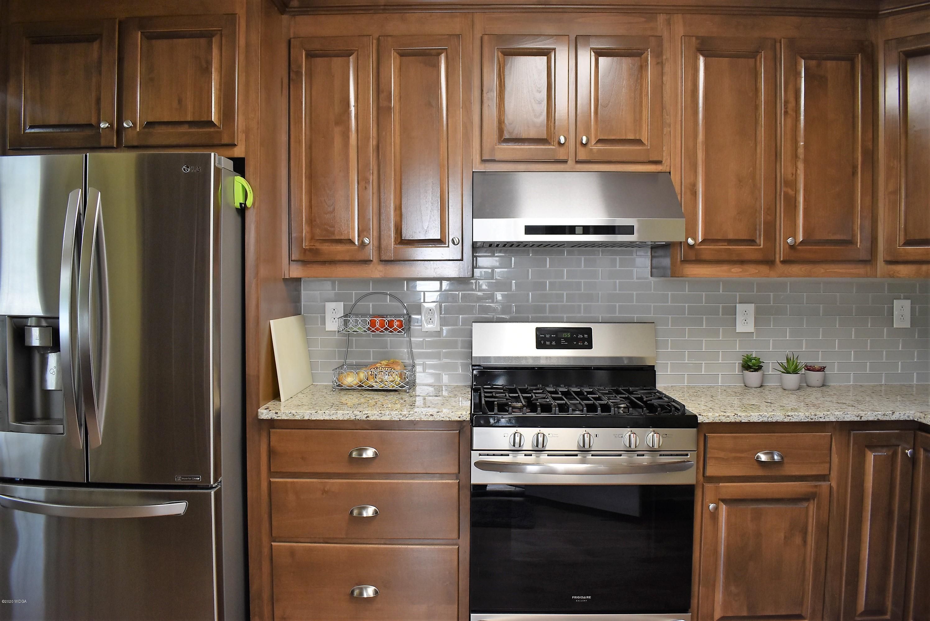 4825 Brookhaven Road Macon, GA 31206 - Photo 9 of 30 a kitchen with granite countertop a refrigerator stove and cabinets